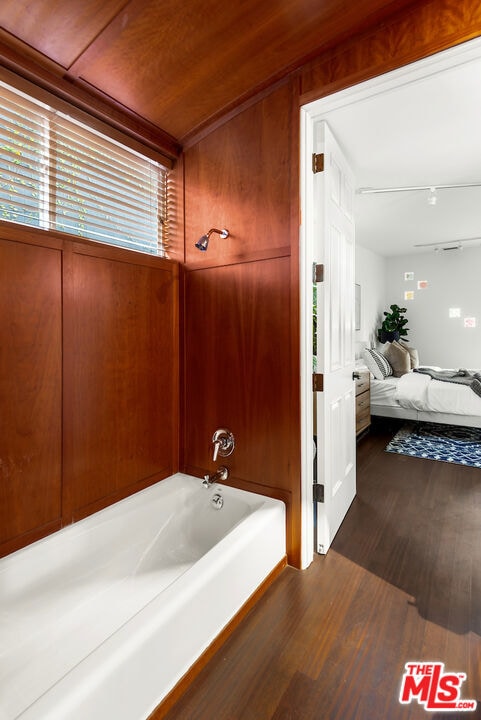 bathroom with hardwood / wood-style flooring and shower / bath combination