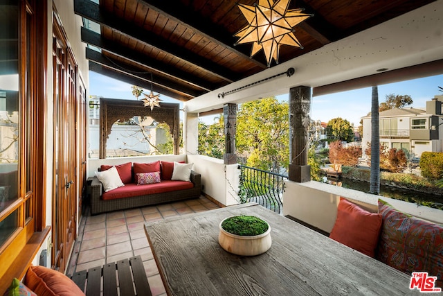 sunroom / solarium featuring lofted ceiling with beams and wood ceiling