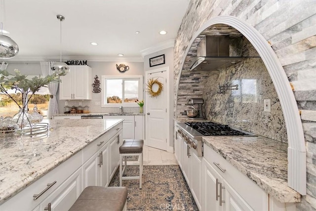 kitchen featuring white cabinetry, sink, decorative light fixtures, and light stone counters