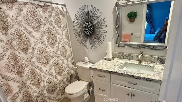 bathroom with walk in shower, vanity, and toilet