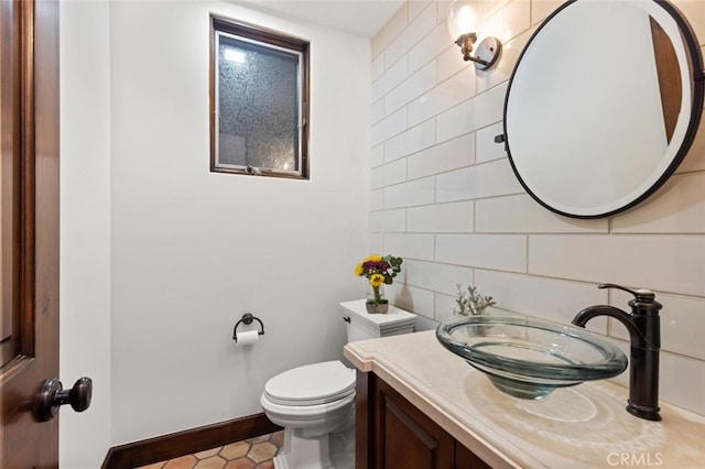 bathroom with vanity, tile walls, and toilet