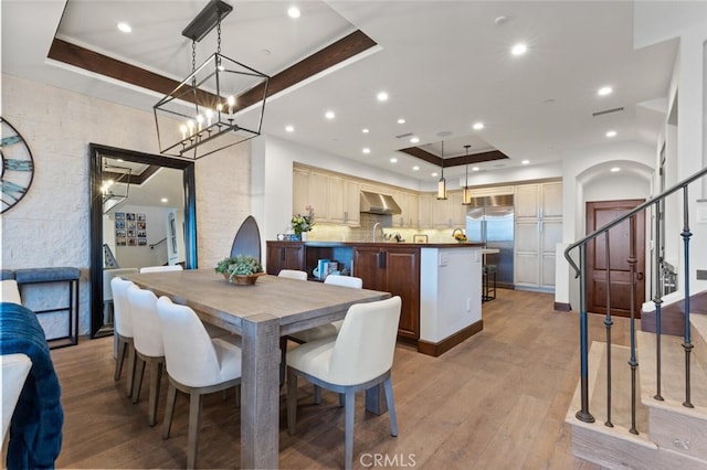 dining room with light hardwood / wood-style flooring and a tray ceiling