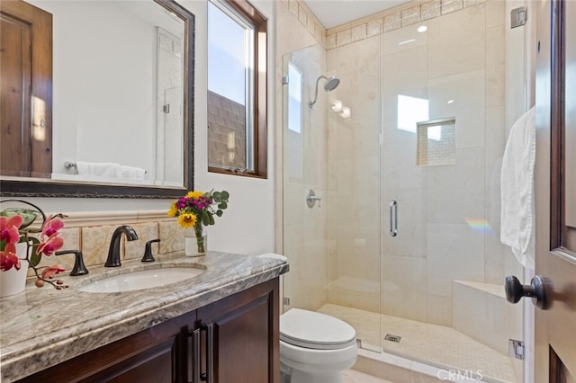 bathroom with tasteful backsplash, vanity, toilet, and walk in shower