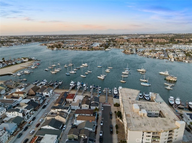 aerial view at dusk featuring a water view