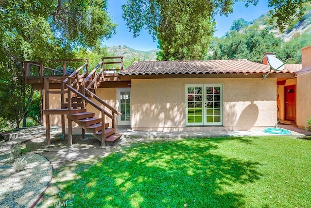 rear view of house featuring a yard and a deck with mountain view