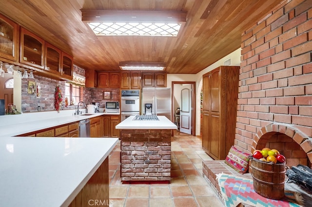 kitchen with sink, appliances with stainless steel finishes, light tile patterned flooring, wooden ceiling, and kitchen peninsula