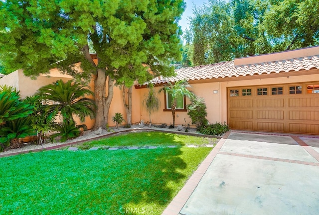 mediterranean / spanish house with a garage and a front lawn