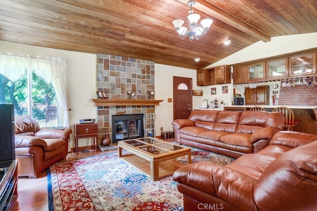 living room featuring wood ceiling, an inviting chandelier, wood-type flooring, lofted ceiling with beams, and a large fireplace