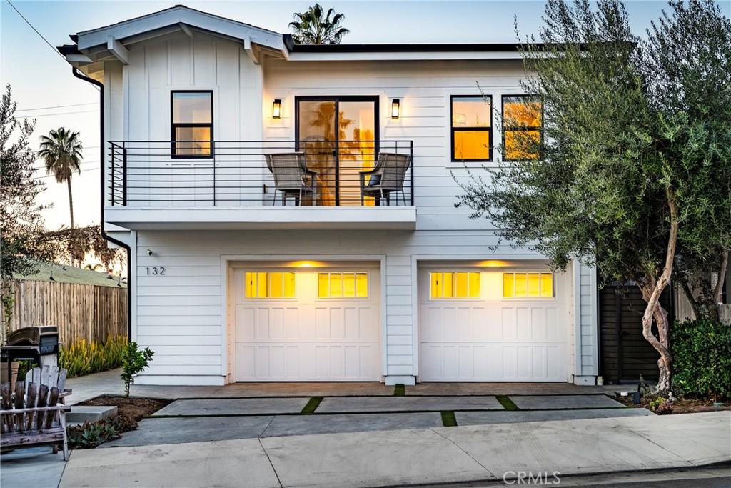 view of front of property featuring a garage and a balcony