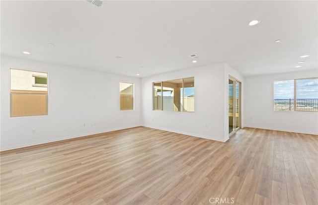 spare room featuring recessed lighting, baseboards, and light wood-style floors