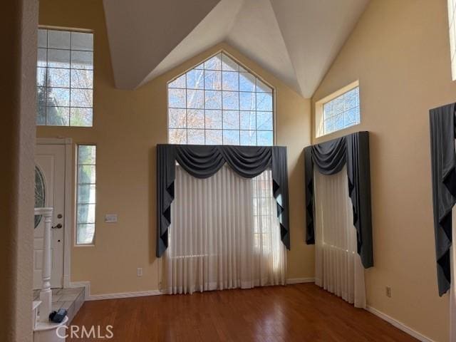 foyer with hardwood / wood-style flooring and high vaulted ceiling