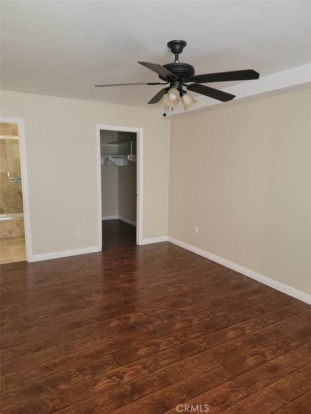 empty room featuring dark wood-type flooring and ceiling fan