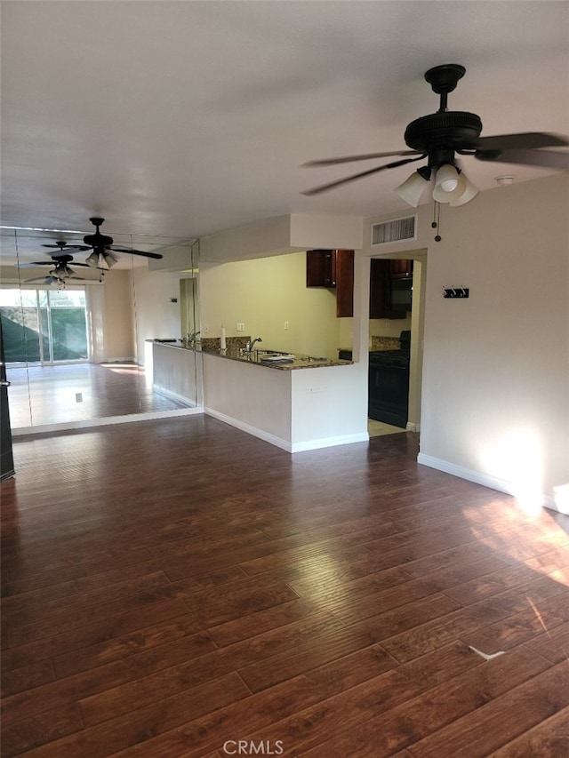 unfurnished living room with sink, dark wood-type flooring, and ceiling fan