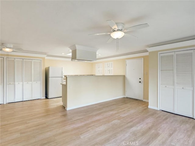 kitchen with white refrigerator, ceiling fan, ornamental molding, and light hardwood / wood-style floors