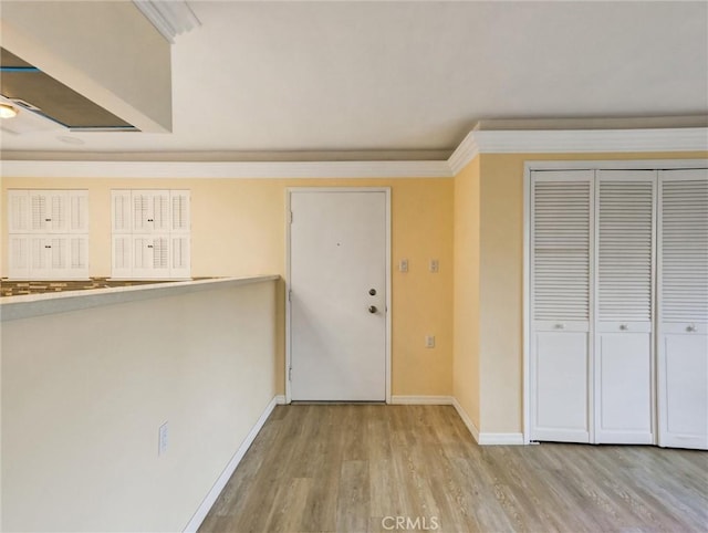 entrance foyer featuring crown molding and light hardwood / wood-style flooring