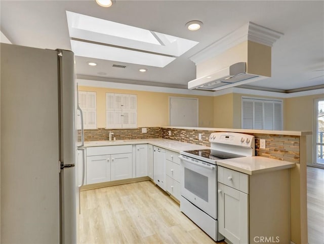 kitchen featuring white cabinets, decorative backsplash, ornamental molding, kitchen peninsula, and white appliances