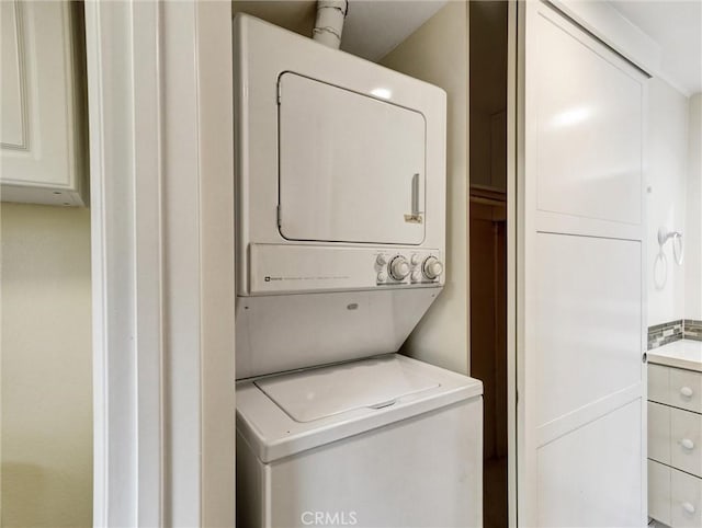 washroom featuring stacked washer and clothes dryer