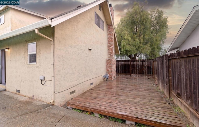 property exterior at dusk with a wooden deck