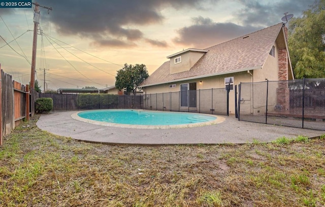 pool at dusk with a patio