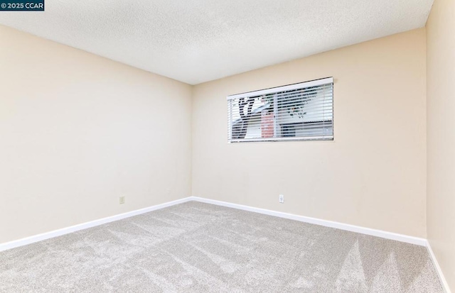 carpeted empty room featuring a textured ceiling