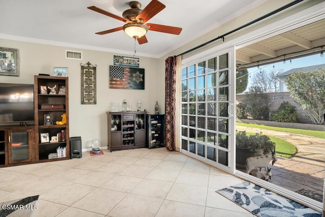 interior space featuring light tile patterned flooring, ceiling fan, and ornamental molding