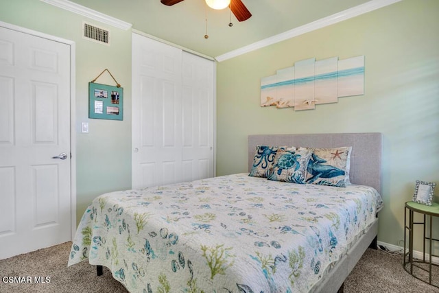 carpeted bedroom with ornamental molding, ceiling fan, and a closet