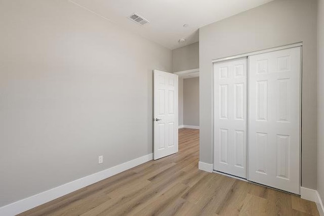 unfurnished bedroom featuring a closet and light hardwood / wood-style flooring