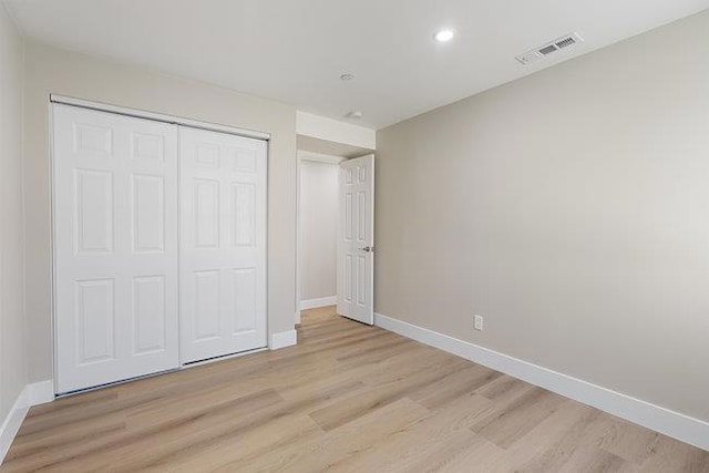 unfurnished bedroom with light hardwood / wood-style floors and a closet