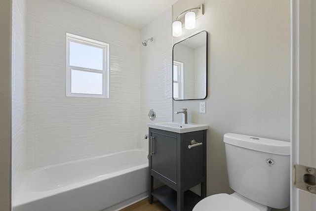 full bathroom with vanity, tiled shower / bath combo, and toilet