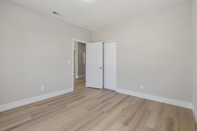 unfurnished bedroom with a closet and light wood-type flooring