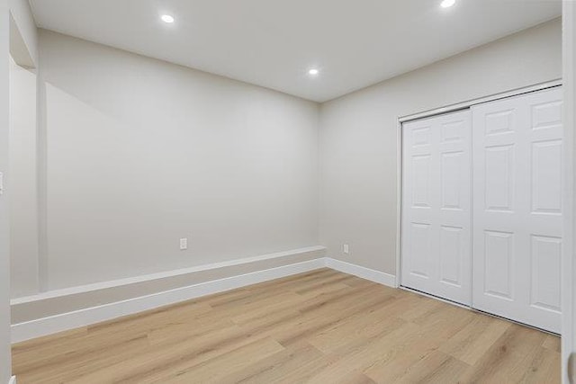 unfurnished bedroom featuring light hardwood / wood-style floors and a closet