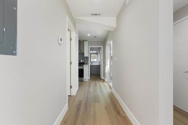 corridor featuring light hardwood / wood-style floors and electric panel