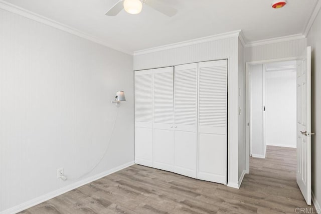 unfurnished bedroom with crown molding, ceiling fan, light hardwood / wood-style floors, and a closet