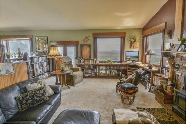 carpeted living room featuring a brick fireplace and vaulted ceiling