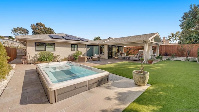 back of property featuring a yard, an outdoor hangout area, a patio, and solar panels