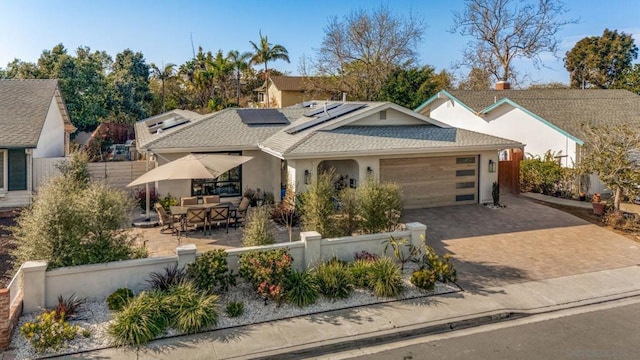 view of front of home with a garage and solar panels