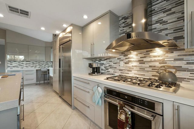 kitchen with light tile patterned flooring, appliances with stainless steel finishes, extractor fan, and gray cabinetry