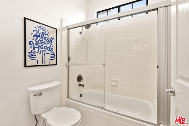 bathroom with combined bath / shower with glass door and toilet