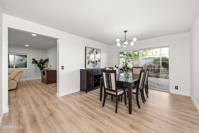 dining room with a notable chandelier and light wood-type flooring