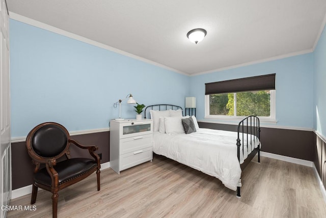 bedroom featuring ornamental molding and light hardwood / wood-style floors