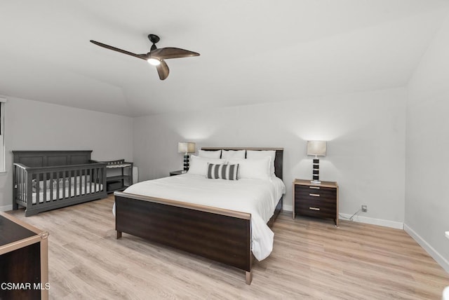 bedroom with ceiling fan, lofted ceiling, and light hardwood / wood-style floors