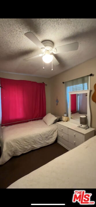 unfurnished bedroom with ceiling fan and a textured ceiling