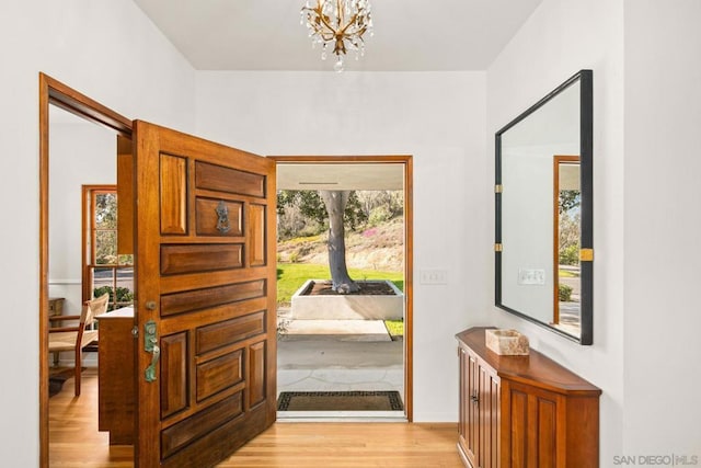 entrance foyer with a notable chandelier and light hardwood / wood-style flooring