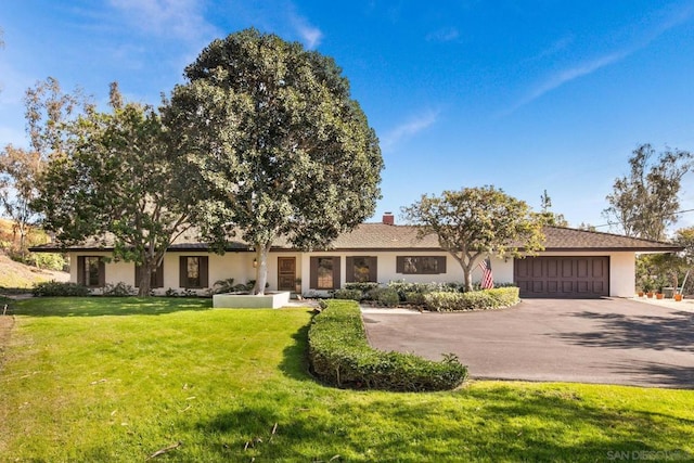 ranch-style house with a garage and a front yard