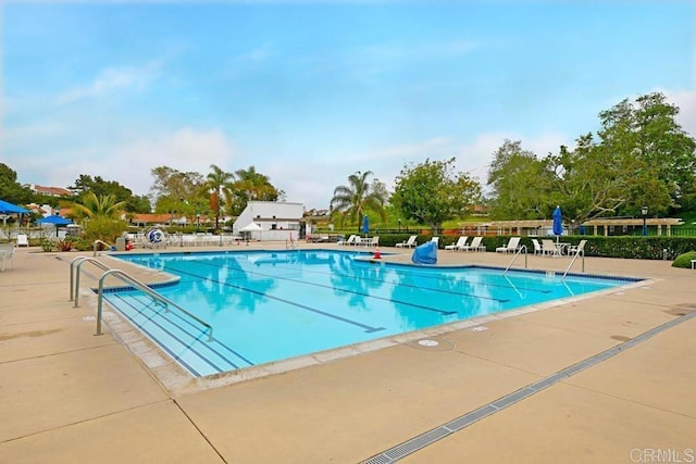 pool with a patio area and fence