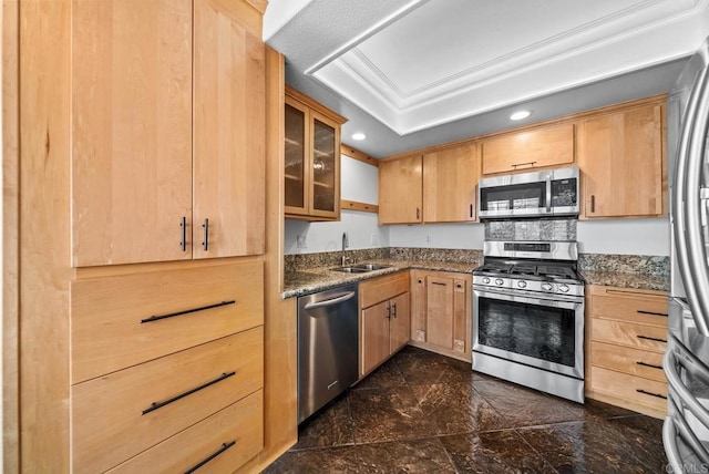 kitchen featuring stainless steel appliances, recessed lighting, a raised ceiling, light brown cabinetry, and a sink