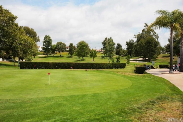 view of community with golf course view and a lawn