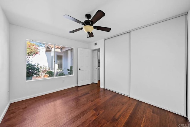 unfurnished bedroom featuring a ceiling fan, a closet, baseboards, and wood finished floors