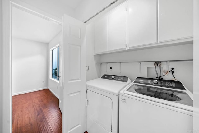 clothes washing area with washing machine and dryer, wood finished floors, cabinet space, and baseboards