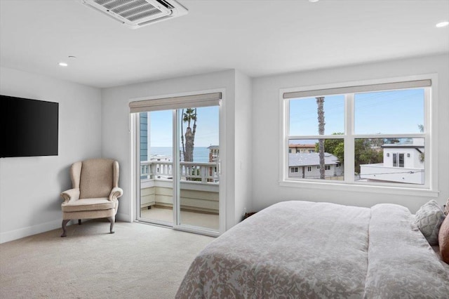 carpeted bedroom featuring a water view and access to exterior